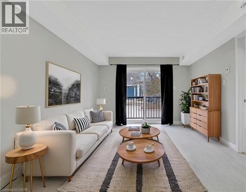 A living room with a white couch, a coffee table, and a painting on the wall.