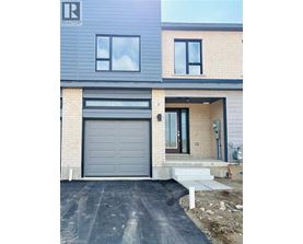 A modern house with a grey garage door is for sale.