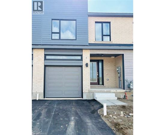 A modern house with a grey garage door is for sale.
