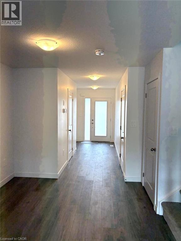 A long hallway with white walls and wood flooring.