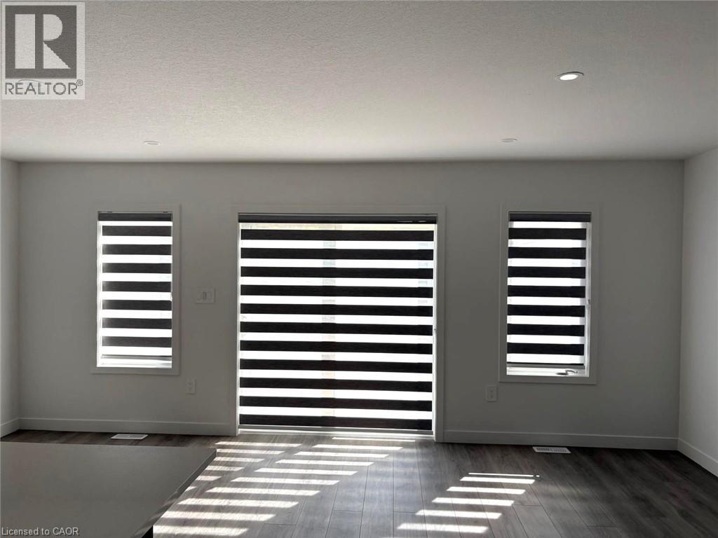 A room with a sliding door and two windows.