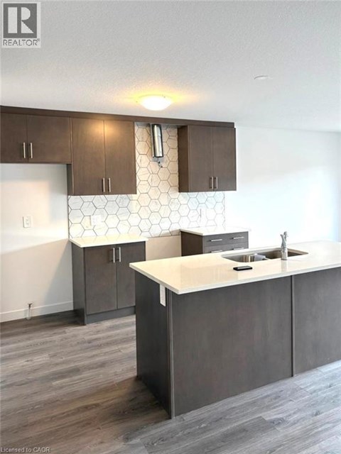 A kitchen with a white counter top and brown cabinets.