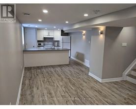 A spacious room with a kitchen island and wood flooring.