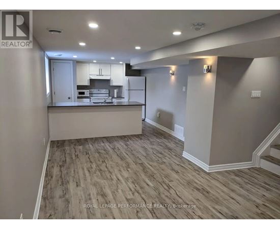 A spacious room with a kitchen island and wood flooring.