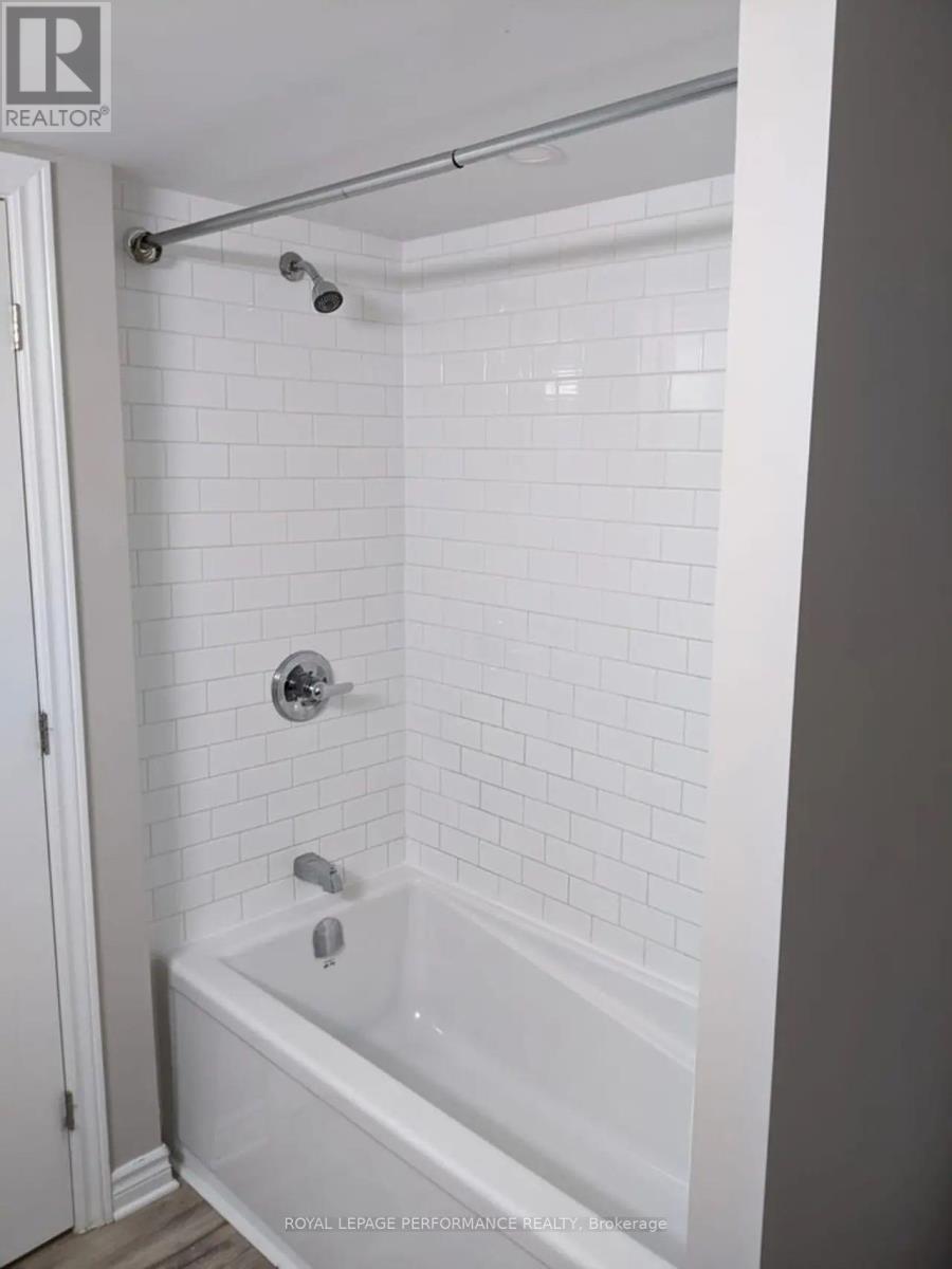 A white bathroom with a white tub and white tiles.
