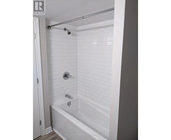 A white bathroom with a white tub and white tiles.