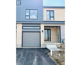 A modern house with a grey garage door is for sale.
