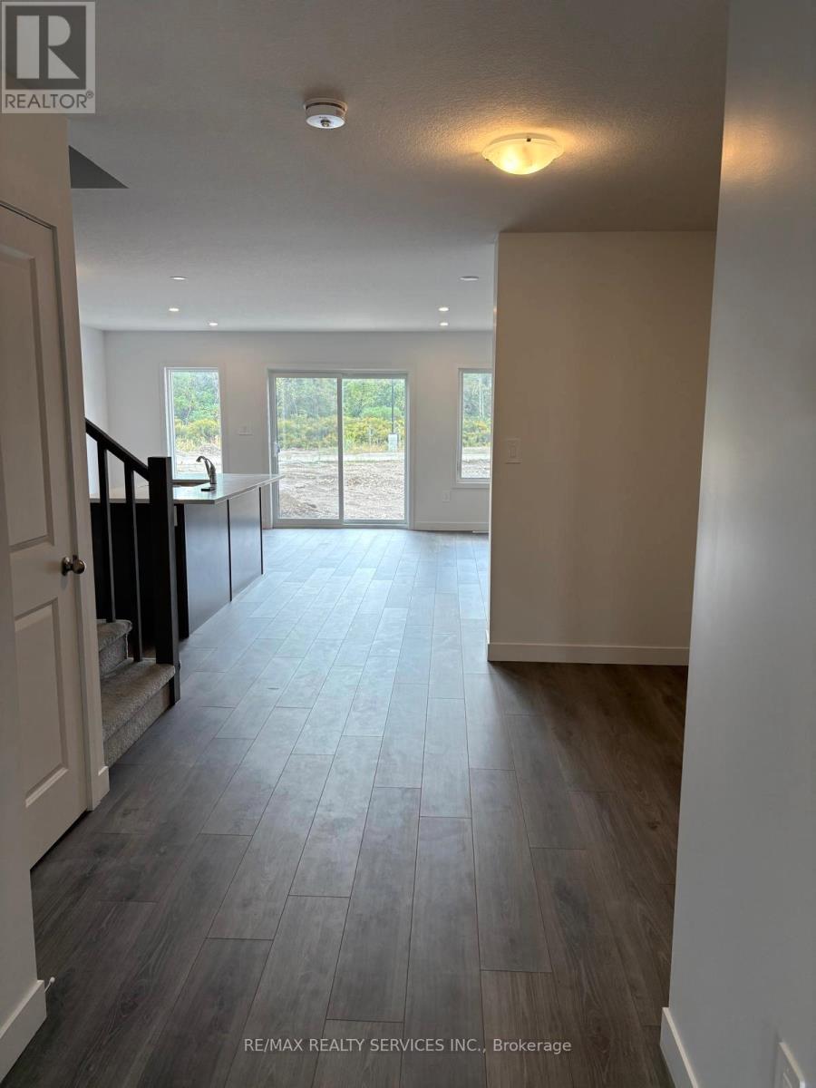 A spacious hallway with a wooden floor and a glass door leading to a balcony.