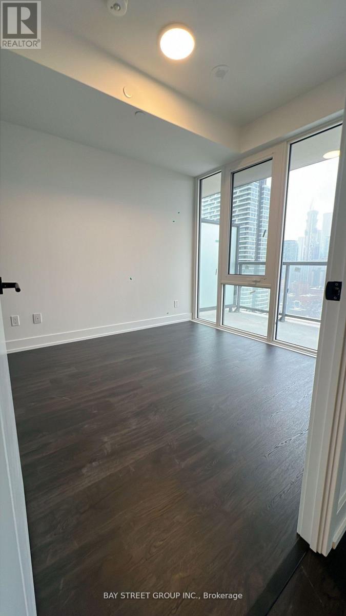 A room with wooden flooring and a large window.