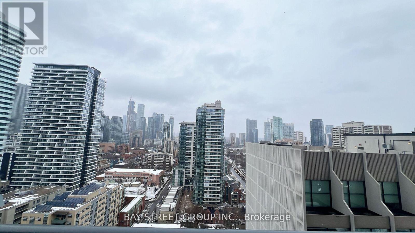 A cityscape with a cloudy sky and buildings of various heights.