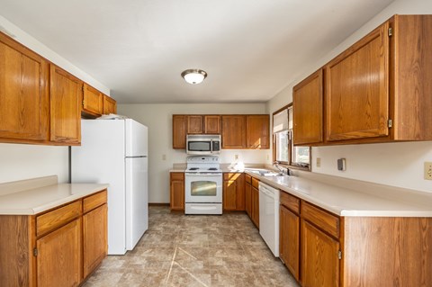 A kitchen with wooden cabinets and white appliances.