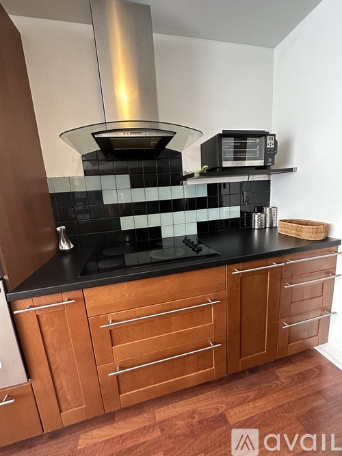 A kitchen with wooden cabinets and a black countertop.