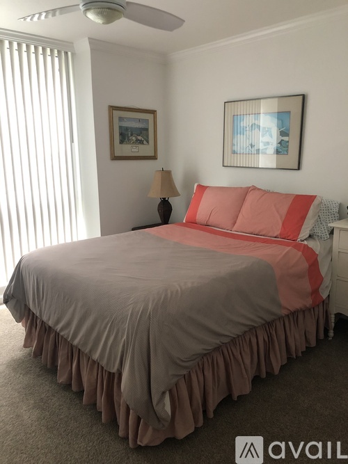 A bedroom with a bed, a lamp, and two pictures on the wall.