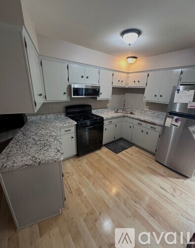 A kitchen with wooden floors and stainless steel appliances.