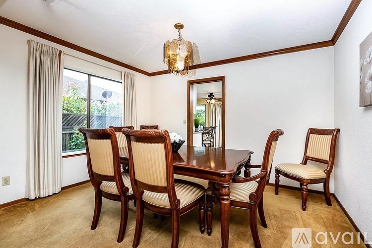 A dining room with a wooden table and chairs.