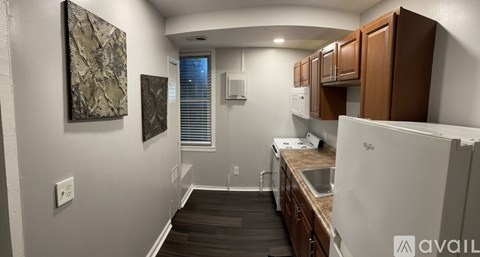 A kitchen with a white fridge and wooden cabinets.