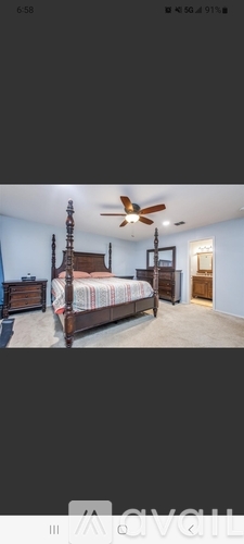 A bedroom with a bed, dresser, and ceiling fan.