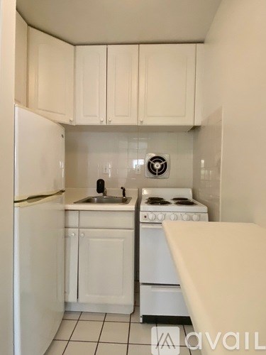 A small kitchen with white appliances and cabinets.