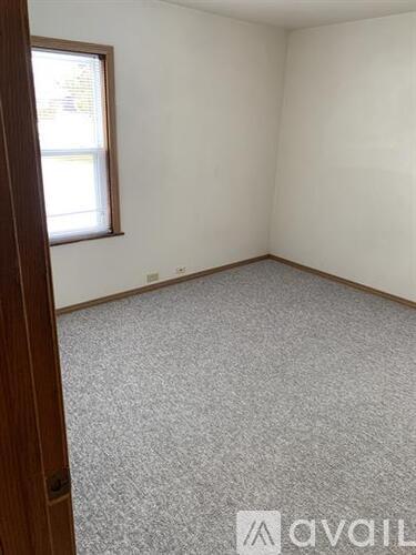 A room with a carpeted floor and a window.