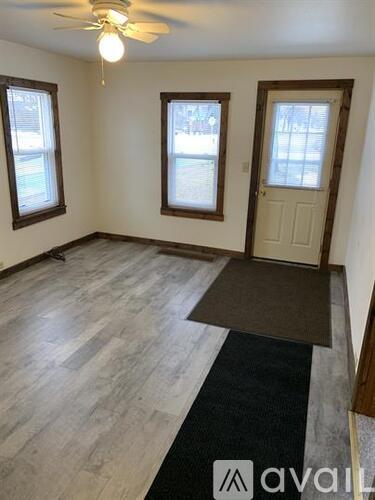 A room with a ceiling fan and a door.