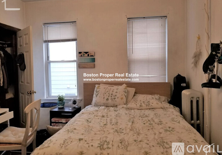 A bedroom with a bed, desk, and chair.