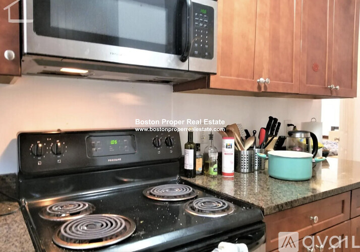 A kitchen with a black stove top oven and a black microwave above it.