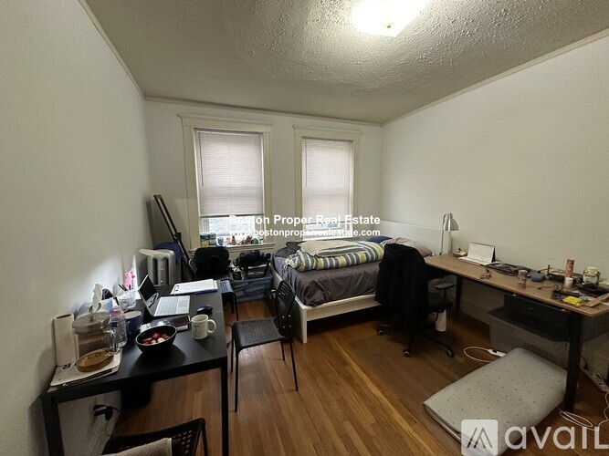 A room with a bed, desk, and chair.