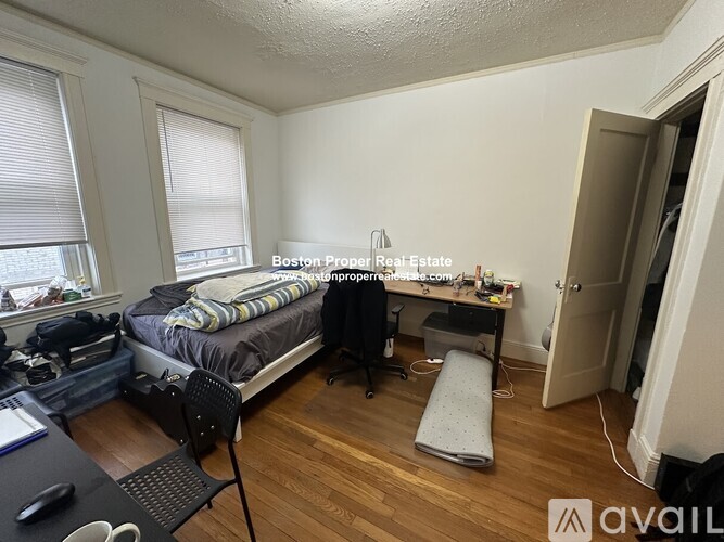 A room with a bed, desk, and chair.