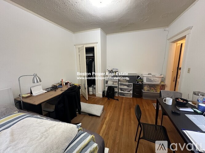 A room with a bed, desk, and chair.