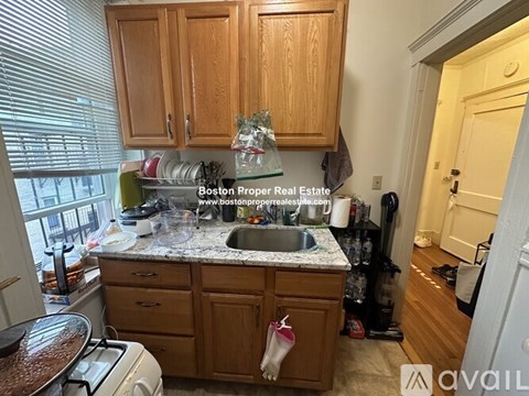 A kitchen with wooden cabinets and a marble countertop.
