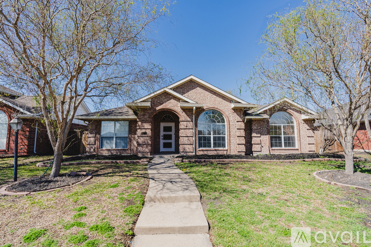 A house with a brick facade and a large front yard.