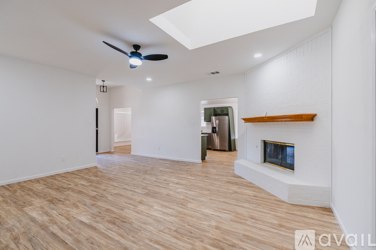 A spacious room with a fireplace and a ceiling fan.