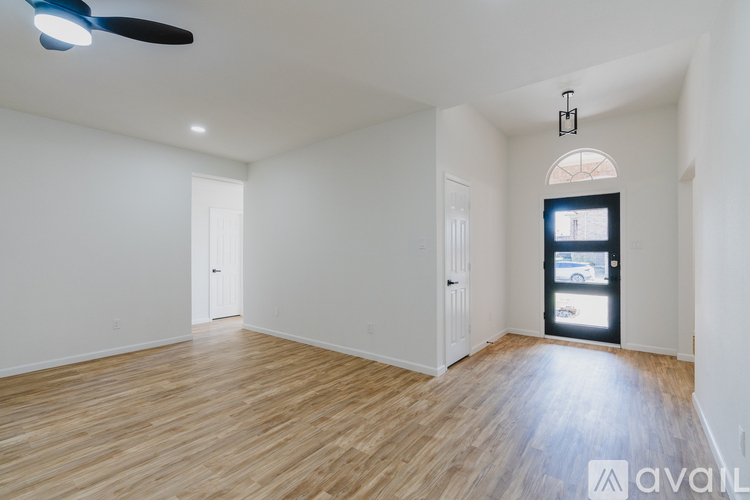 A room with wooden flooring and a ceiling fan.