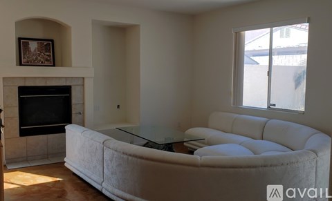 A living room with a white couch and a fireplace.