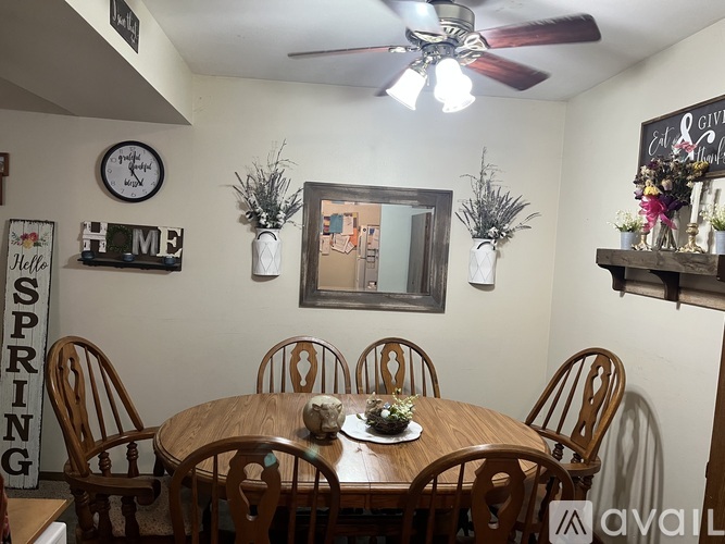 A dining room with a wooden table and chairs.