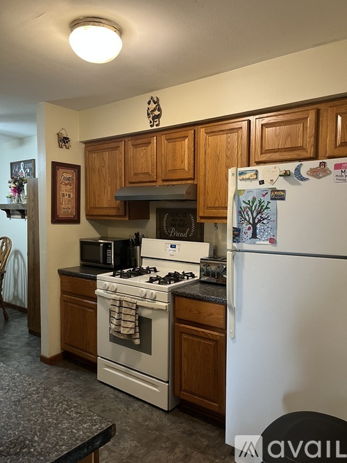 A kitchen with a white refrigerator and a white stove.