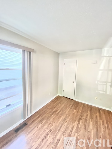 A room with wooden flooring and a white door.