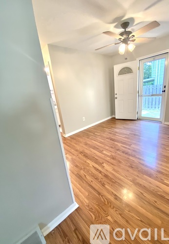 A room with wooden flooring and a ceiling fan.