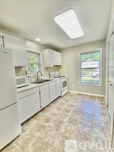 A kitchen with white appliances and cabinets.