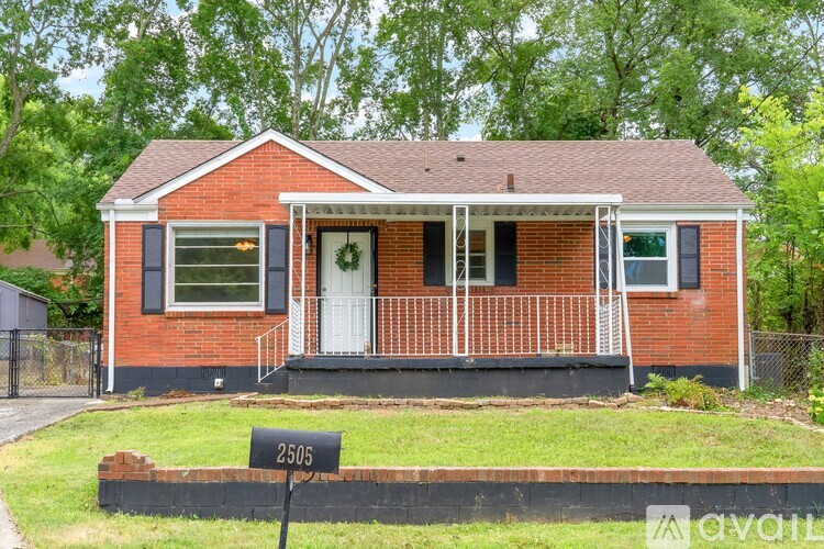 A red brick house with a black mailbox number 2305.