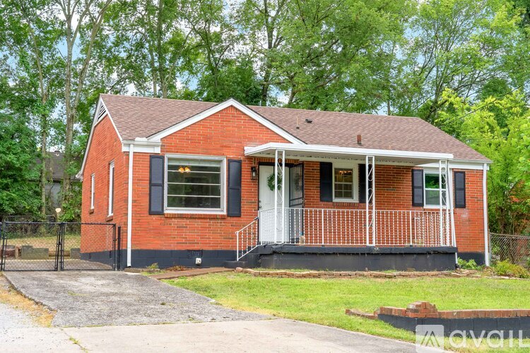 A red brick house with a white porch.