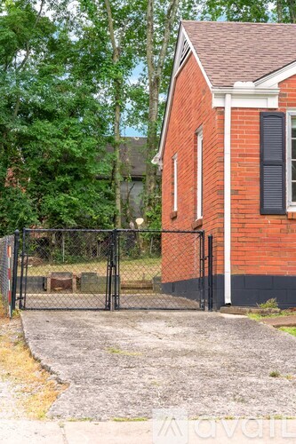 A red brick house with a black gate in front.
