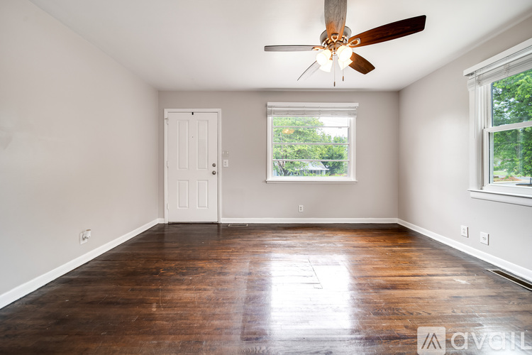A room with a wooden floor and a ceiling fan.