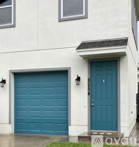 A white house with a blue door and a garage door.