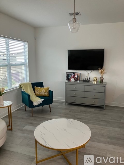 A living room with a blue chair and a white coffee table.