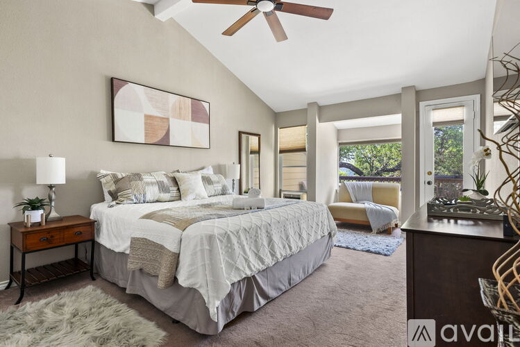 A bedroom with a large bed and a ceiling fan.
