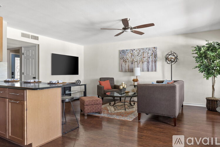 A living room with a grey couch and a wooden cabinet.