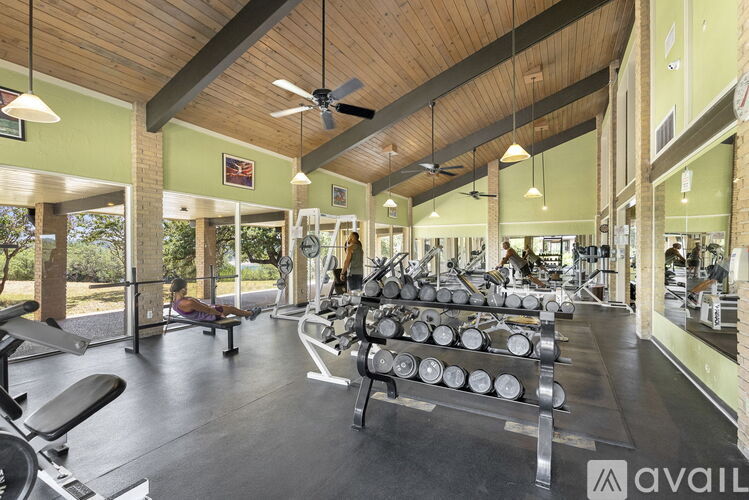A gym with a variety of equipment including weights and a bench.