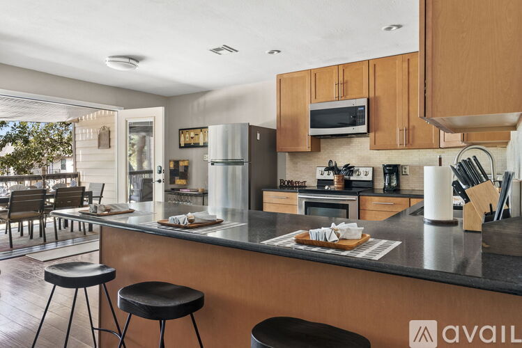 A kitchen with a black countertop and wooden cabinets.
