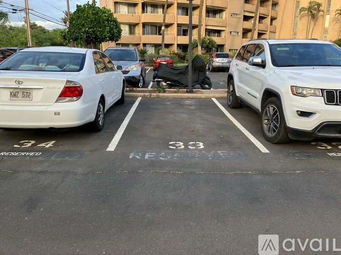 A white car is parked in a parking space with the number 333 on the pavement.